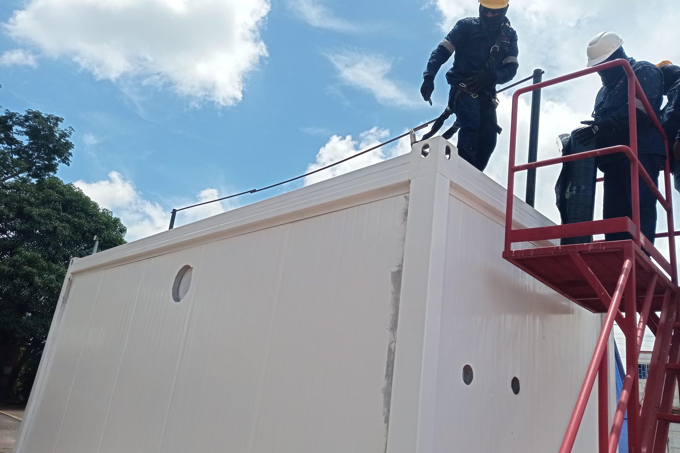 Cuadrilla trabajando sobre un contenedor adecuado, con línea de vida y plataforma de acceso
